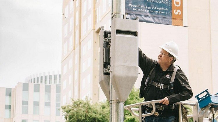 El ingeniero de Verizon, Jerry Bascom, inspecciona un par de cabezas de radio en una pequeña celda simulada cerca del Ayuntamiento de Sacramento.